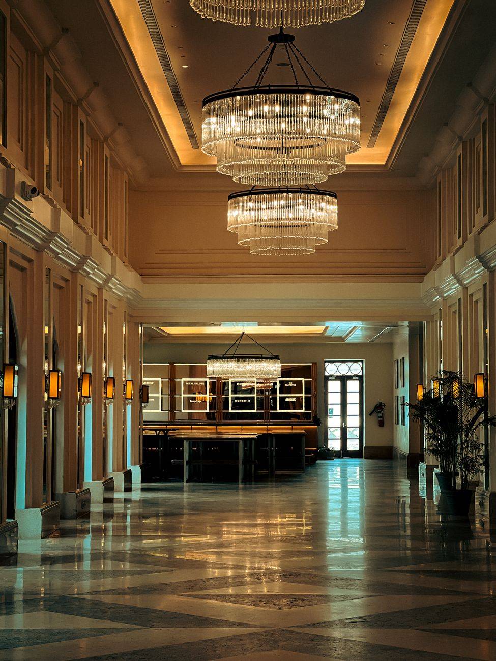Elegant hotel lobby featuring large chandeliers and ambient lighting.