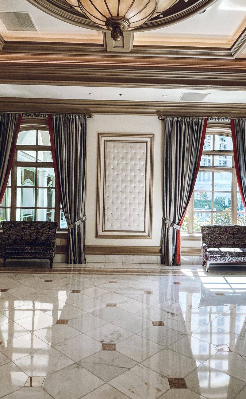 Luxurious hotel lobby interior featuring marble floors and grand curtains with ornate details.
