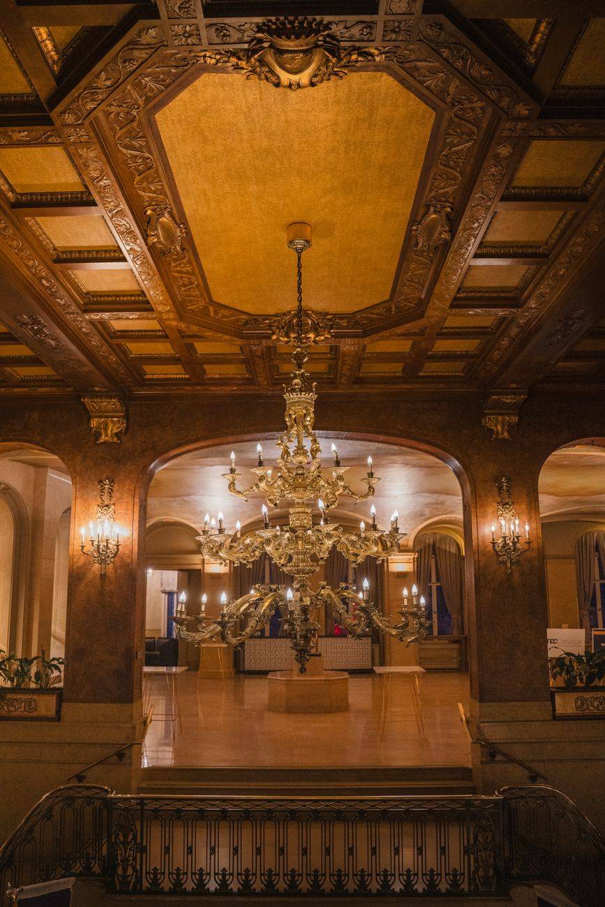 Ornate chandelier and opulent decor in a grand hotel lobby captured in warm lighting.