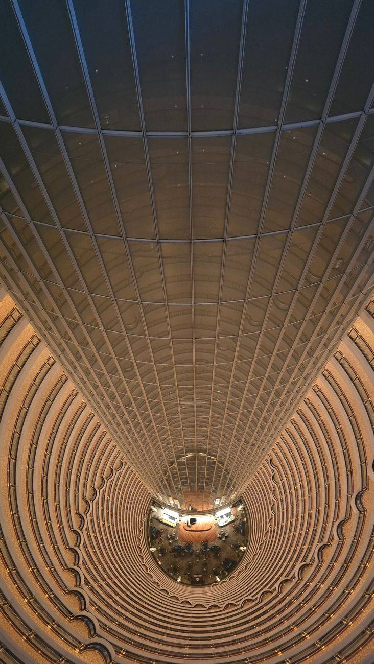 Dramatic overhead view of the futuristic atrium design in a Shanghai skyscraper hotel.