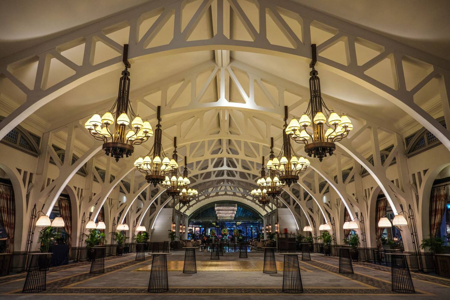 Luxurious interior of a grand hall with ornate chandeliers and architectural detailing in an elegant setting.