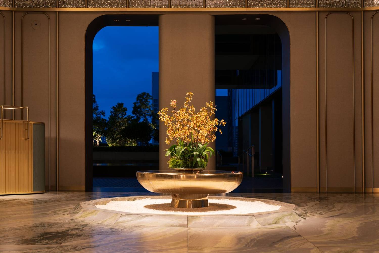 Elegant indoor flower arrangement in a hotel lobby in Singapore at night.