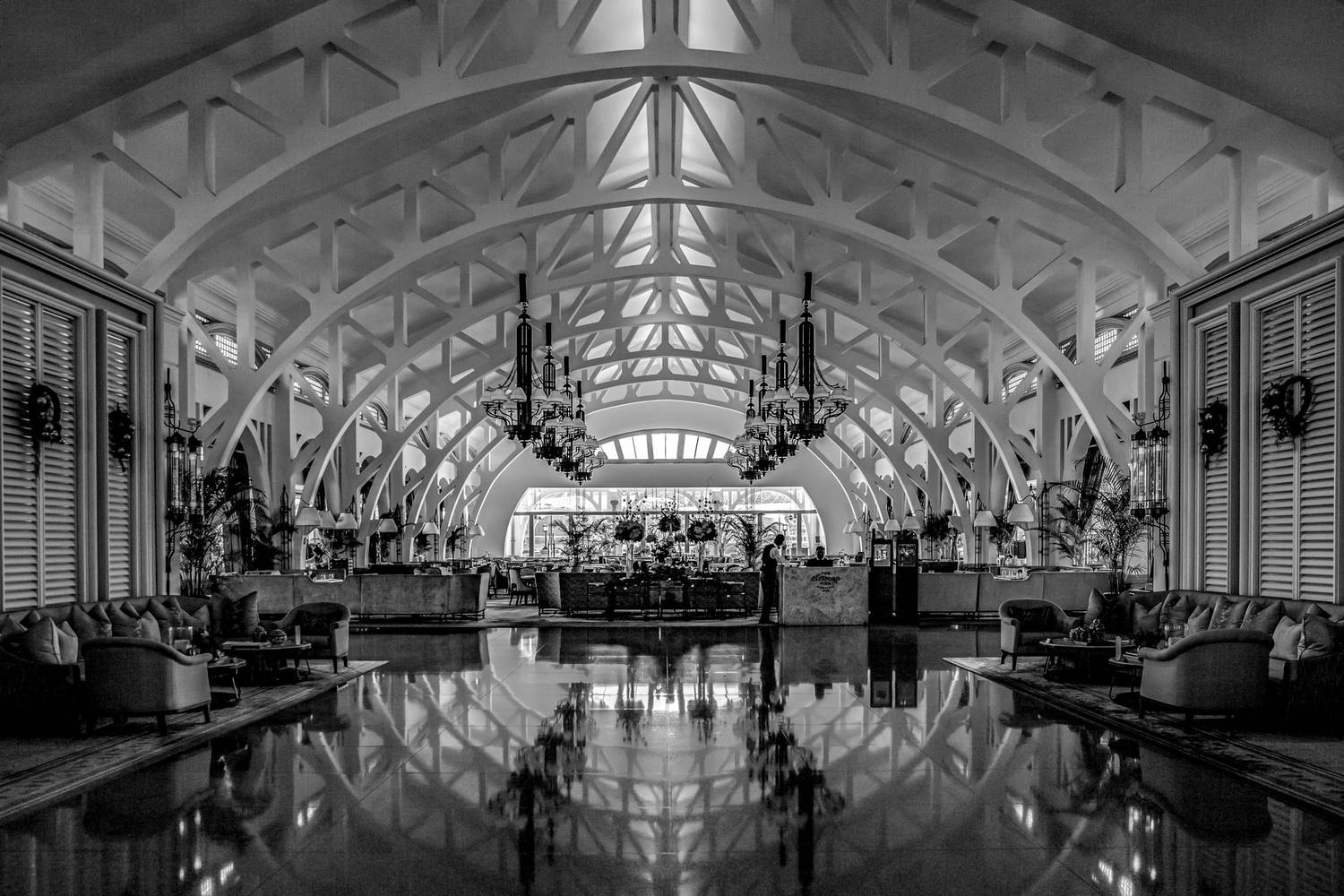 Stunning black and white hotel lobby with chandeliers and elegant furnishings.