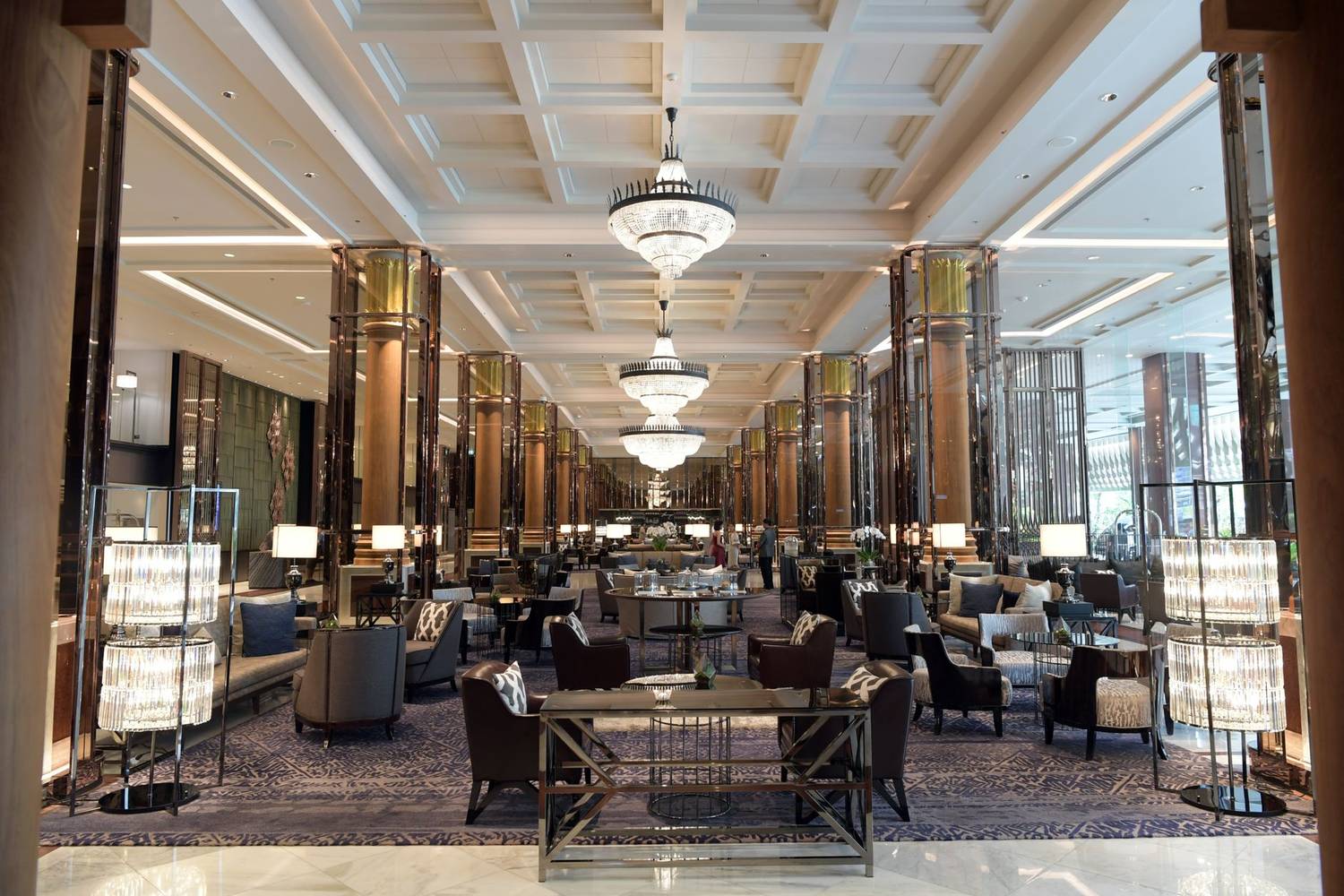 Spacious and elegant hotel lobby with luxurious seating and grand chandeliers, offering a sense of opulence and relaxation.