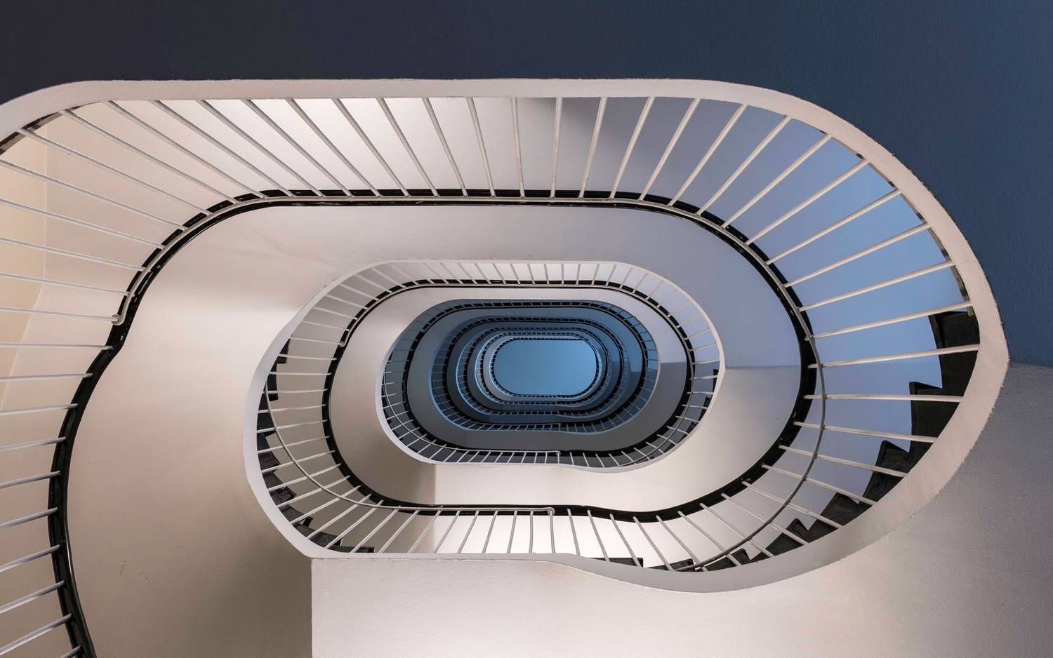 Elegant spiral staircase with geometric design in Hamburg warehouse district.