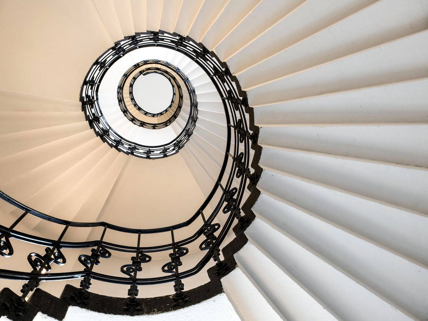 Captivating low-angle view of a spiral staircase with intricate railings in Hamburg.