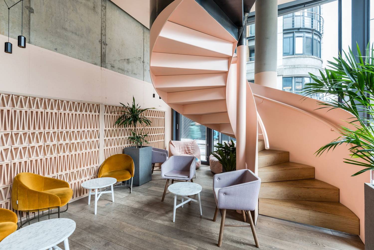 Modern café interior featuring a spiral staircase and stylish seating area with natural light.