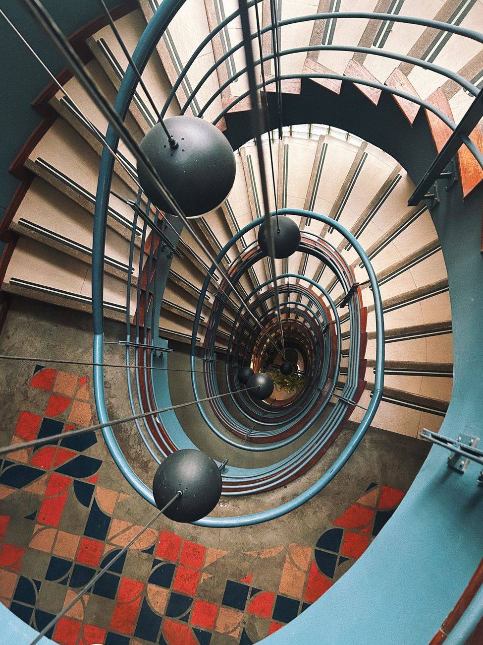 Elegant spiral staircase with geometric floor design in an indoor setting in Bogotá, Colombia.