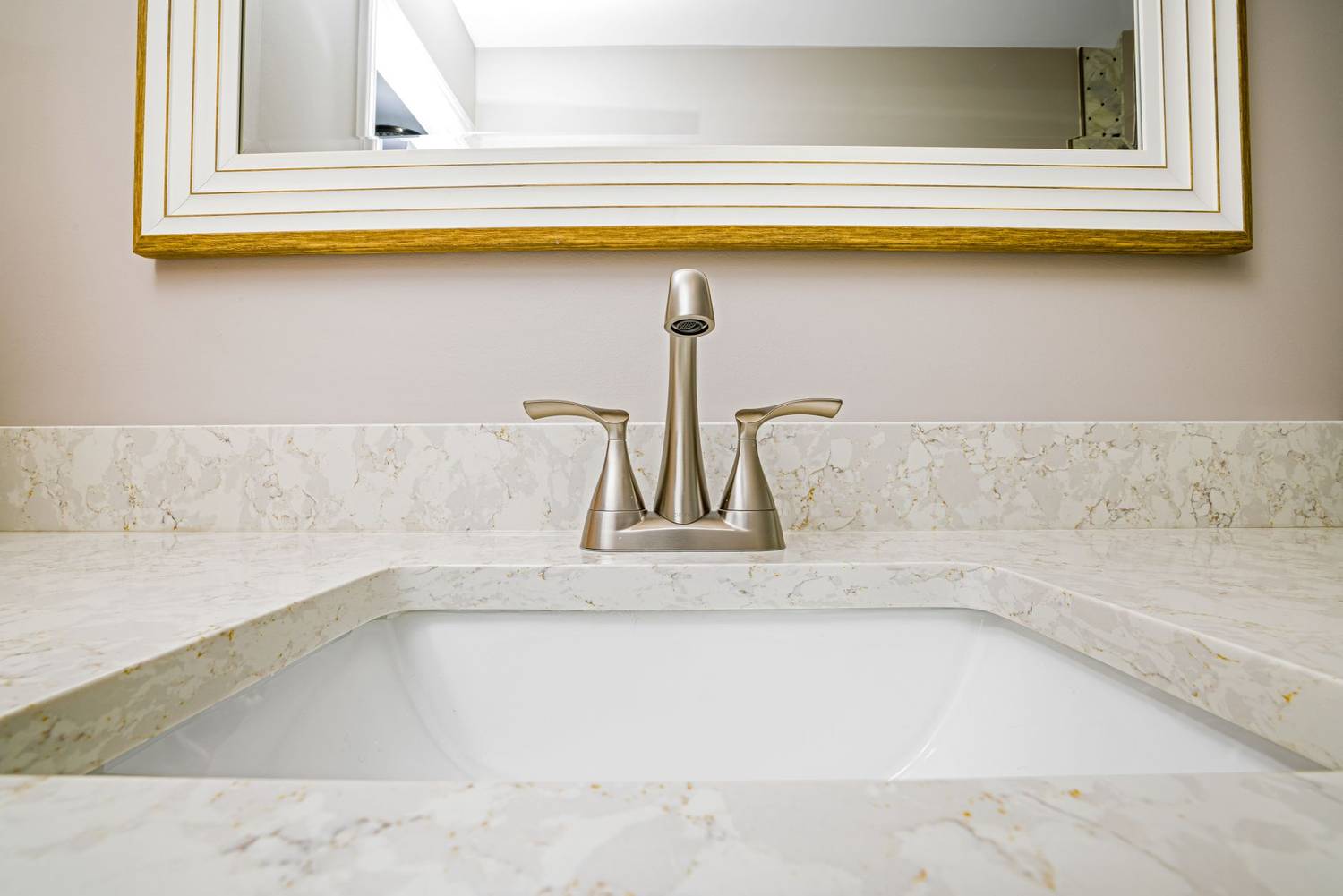Elegant bathroom sink with a minimalist faucet and mirror setup.