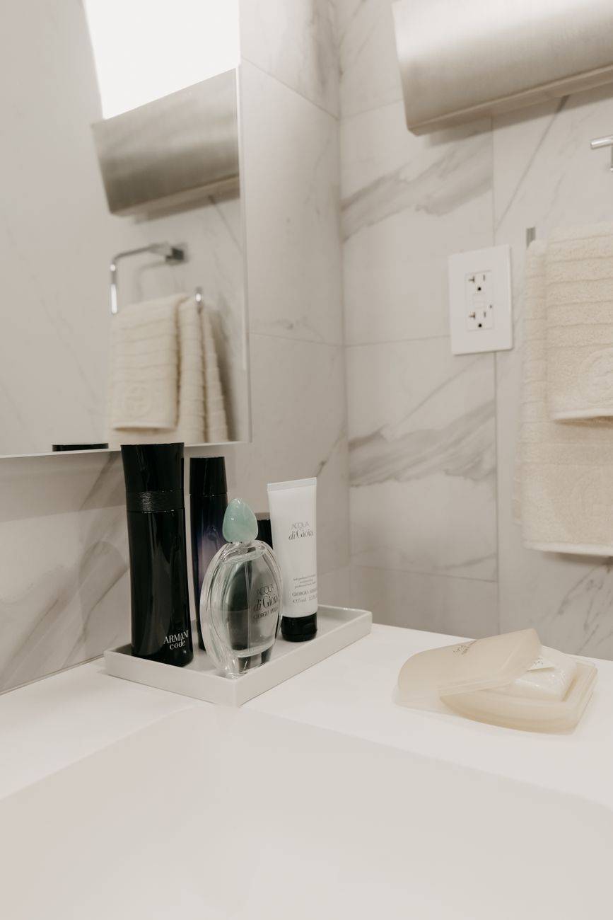 Minimalist bathroom sink with toiletries and a clean, modern design.