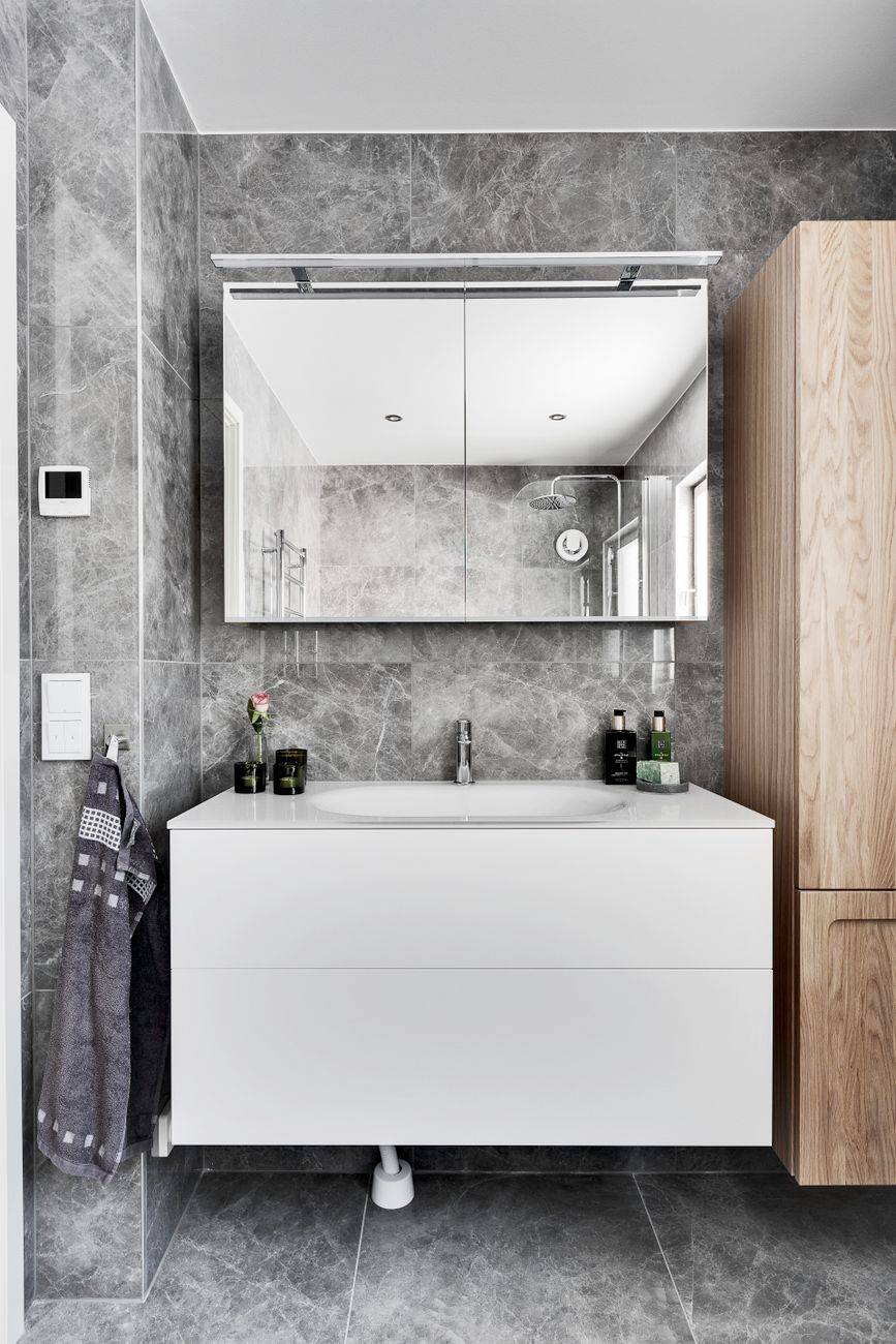 Contemporary bathroom with minimalist design featuring marble walls and sleek furniture.