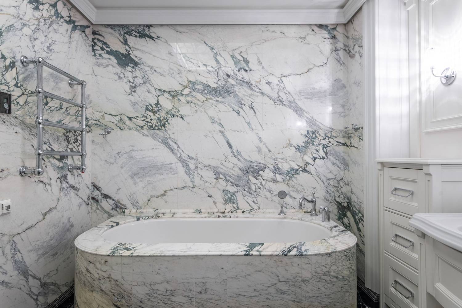 Luxurious modern bathroom with marble tub and wall, featuring elegant design elements.