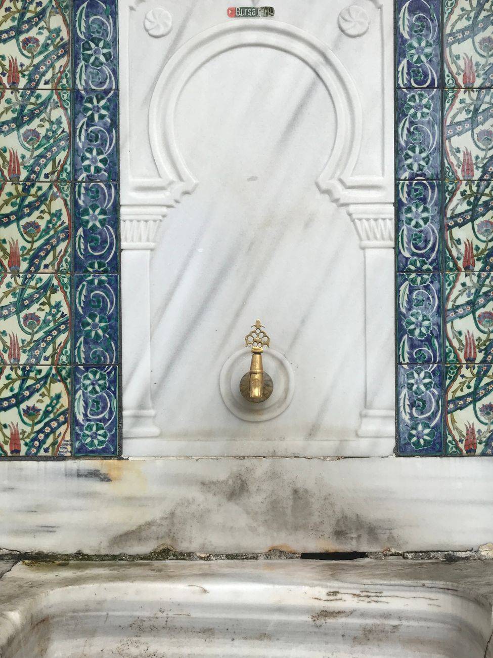 Elegant marble fountain with intricate decorative tiles showcasing traditional eastern architecture.