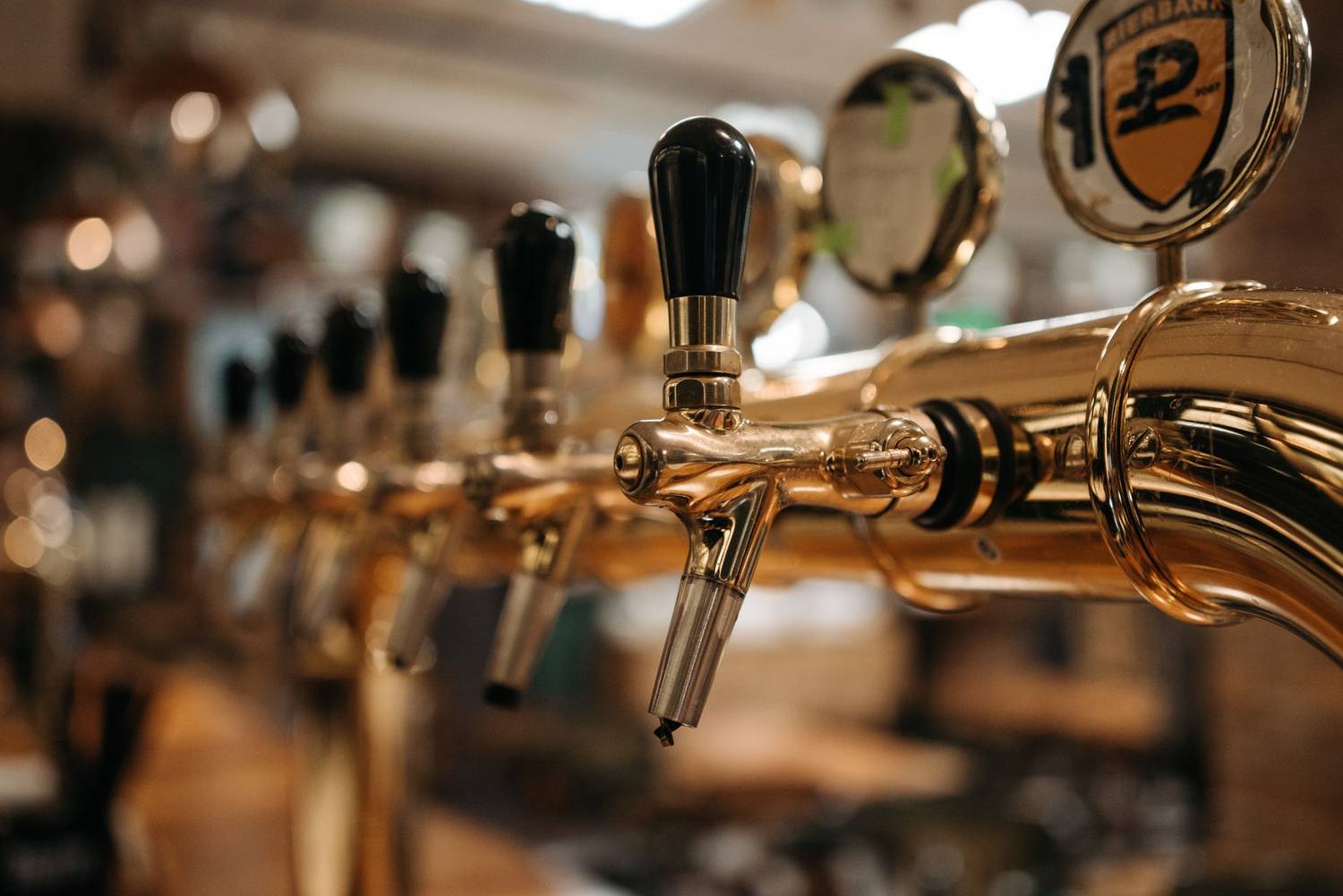 Shiny beer taps in a bar with a warm, inviting atmosphere.