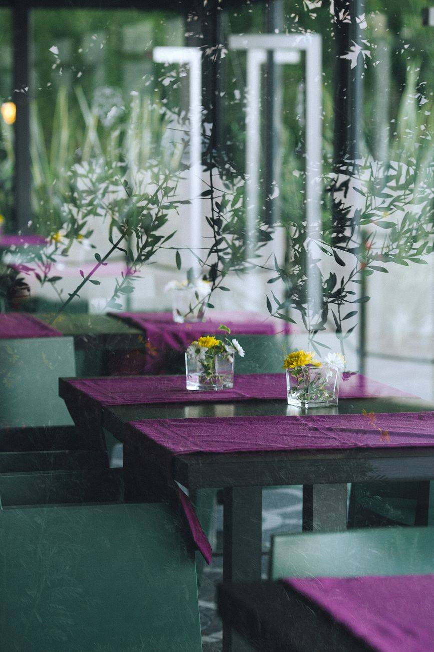 Comfortable elegant banquet table with chairs served with fresh flowers in modern restaurant in daytime