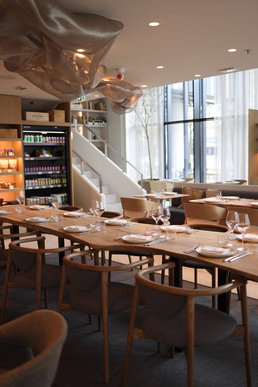 Elegant table setting in a modern restaurant with natural light and artistic decor.
