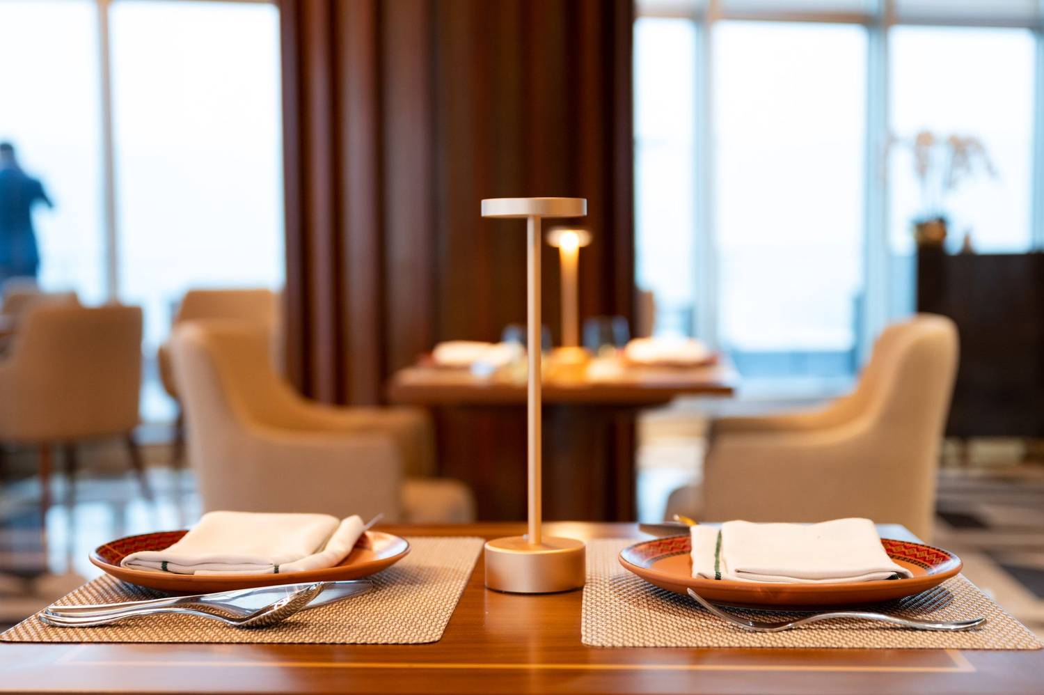 Luxurious restaurant table setting featuring modern table lamp and elegant decor.