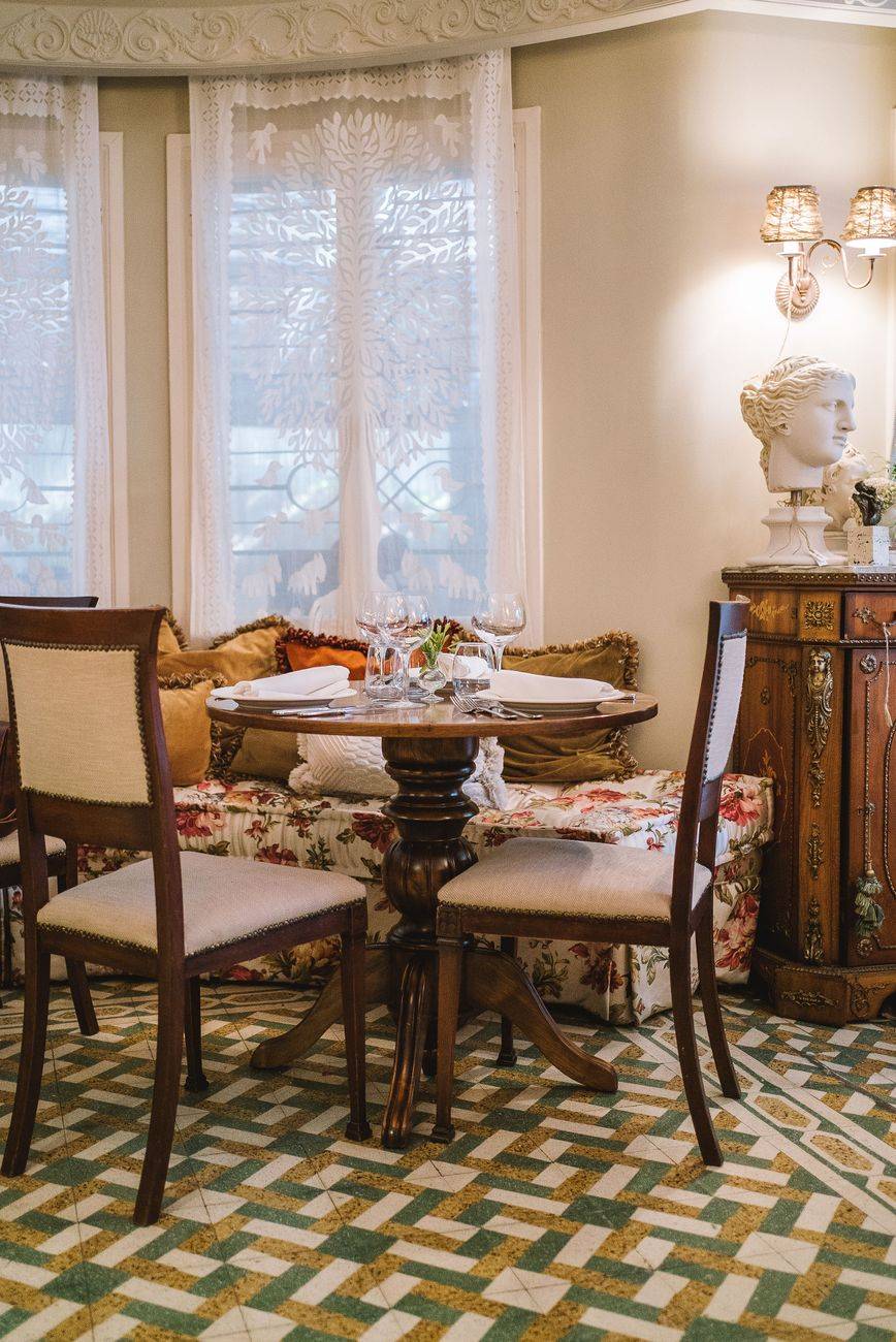 A cozy vintage-style dining area with elegant wooden furniture and decorative elements.