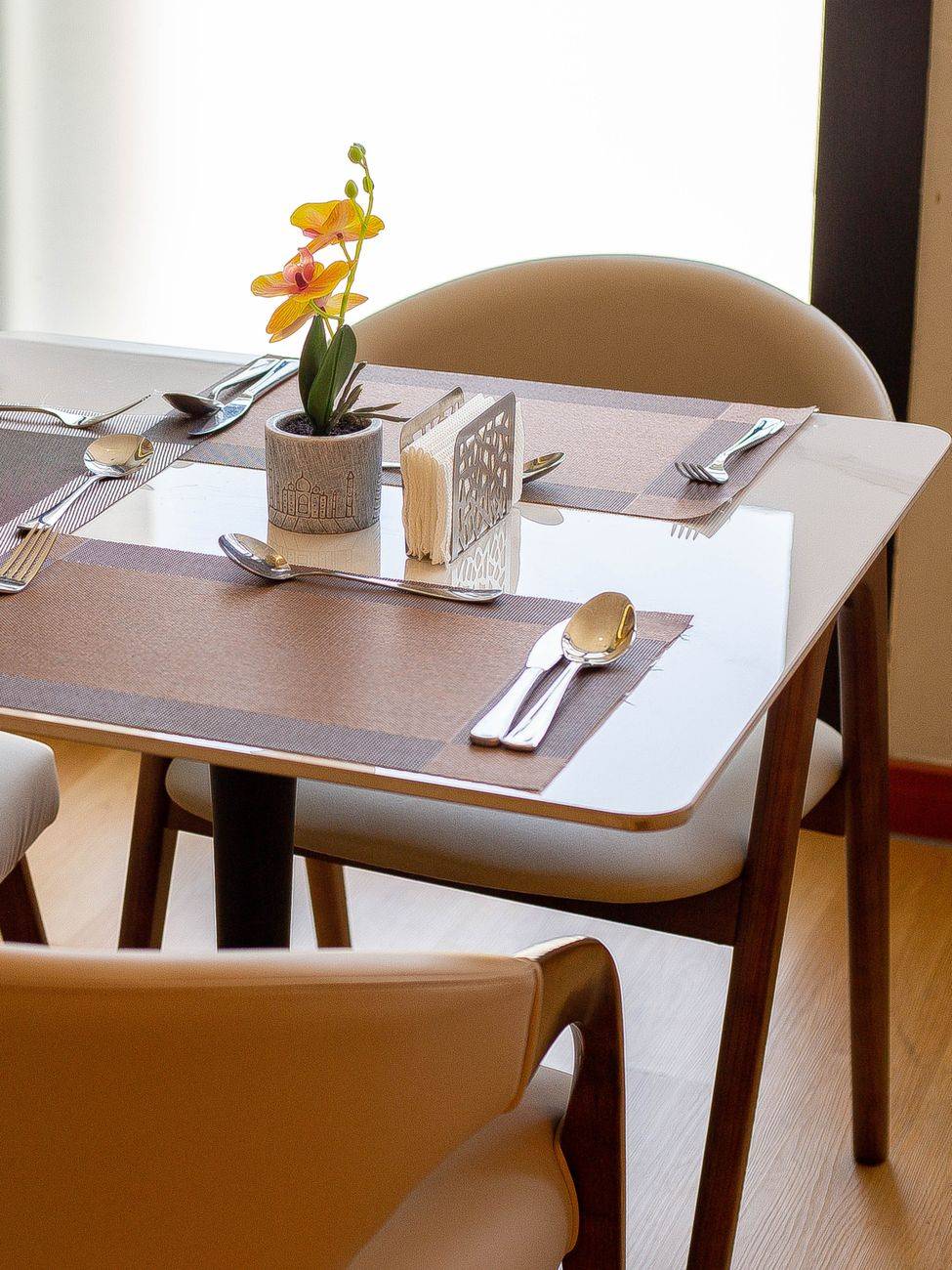 Modern dining table setup with flower in Dar es Salaam cafe.