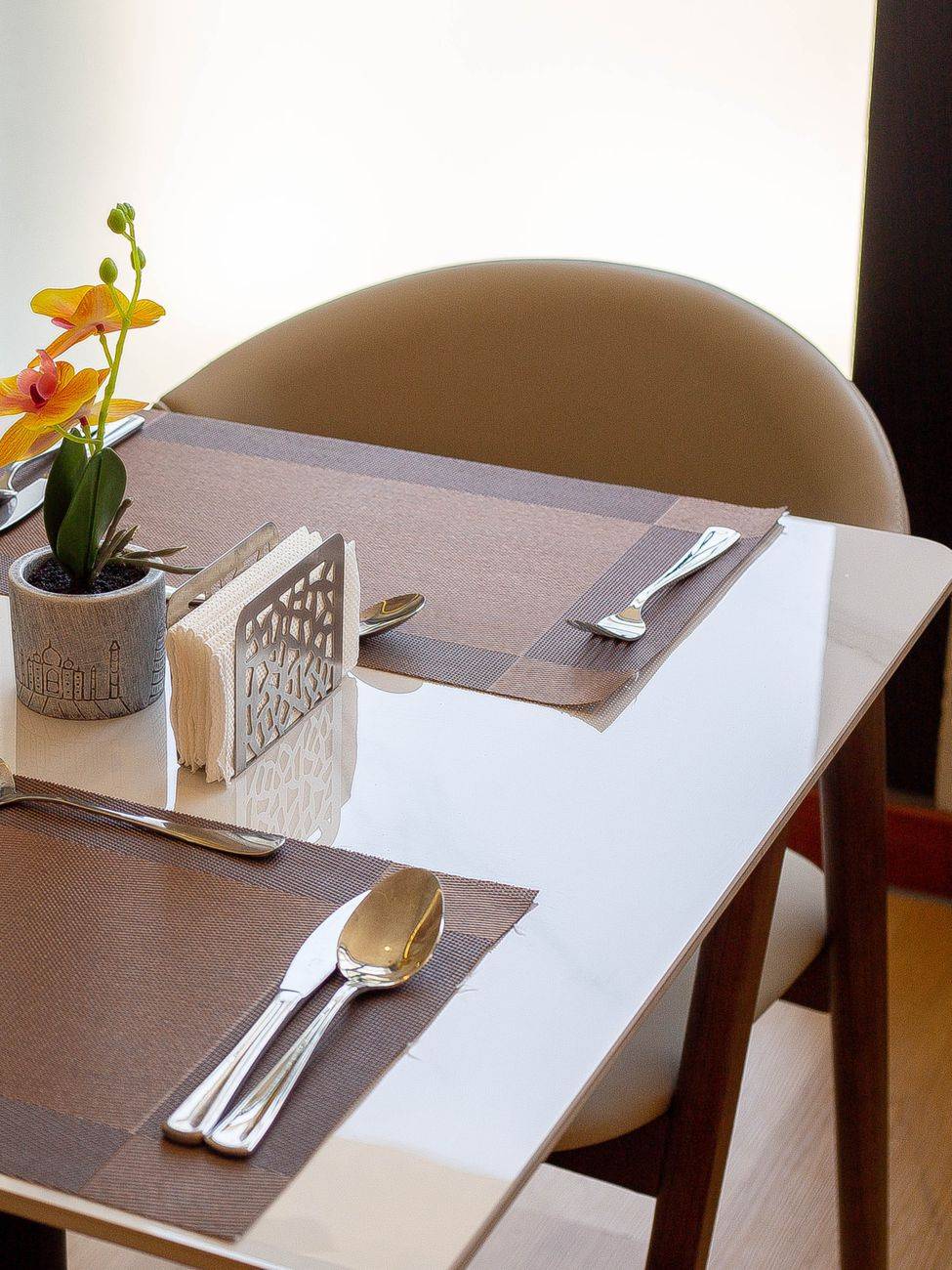 A clean table setting with cutlery and flowers at a modern restaurant in Dar es Salaam, Tanzania.