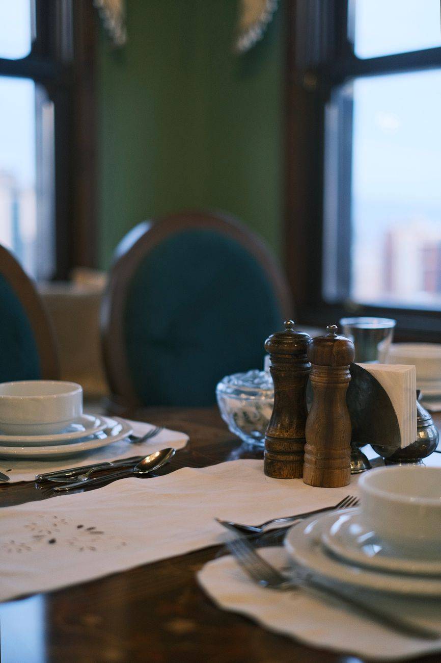 Sophisticated restaurant table setting with cutlery, plates, and window view, creating a refined dining ambiance.