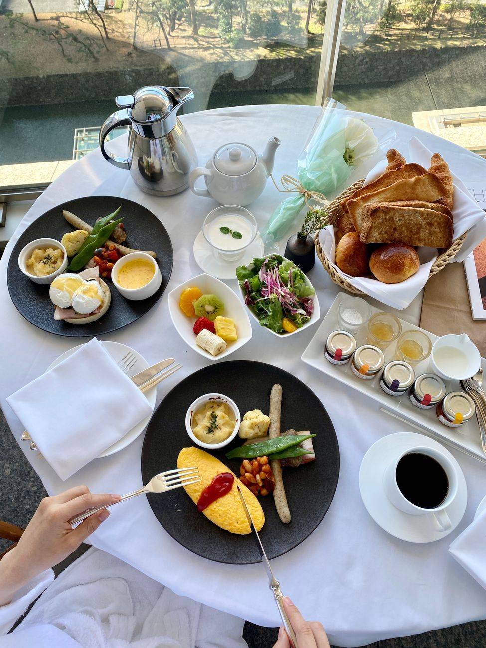 Elegant breakfast setting with omelette and croissants overlooking scenic view.