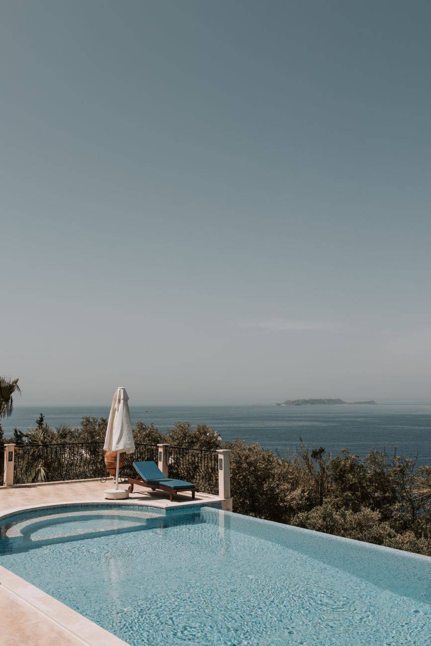 Elegant poolside view overlooking the sea in an Antalya resort, perfect for relaxation.