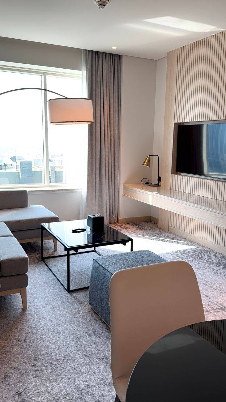 Stylishly decorated hotel room with modern furniture and natural sunlight.