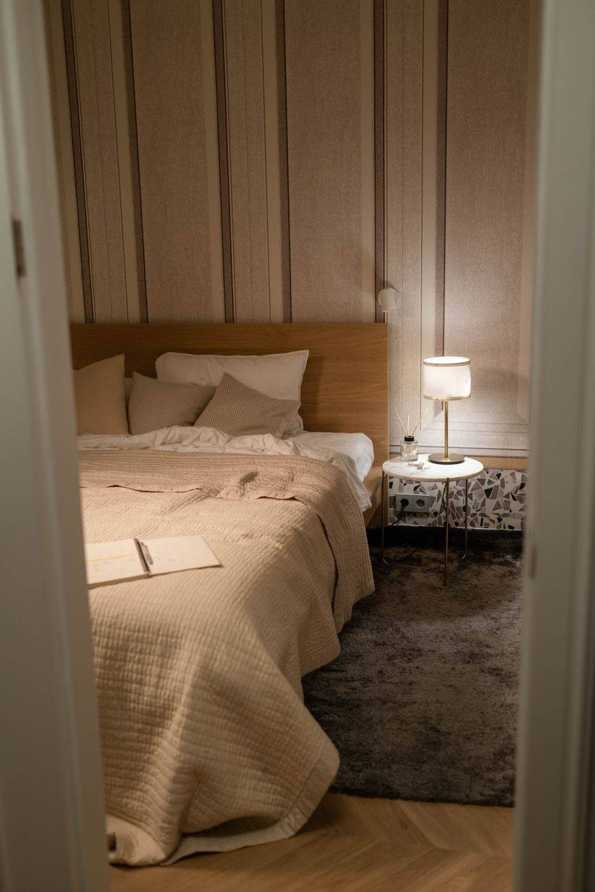 Warm and inviting bedroom with a wooden bed, soft lighting, and modern decor.