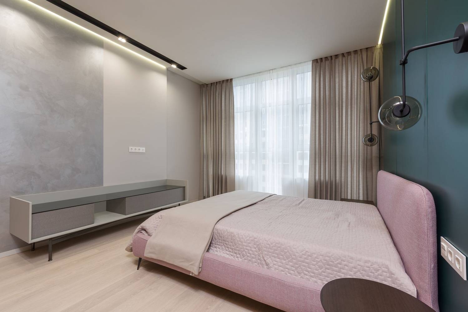 Interior of bedroom with minimalist wooden furniture and comfortable bed placed near wall with creative lamps