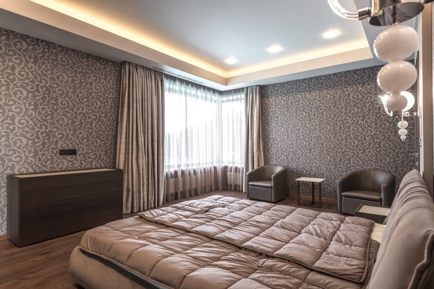 Spacious modern bedroom featuring elegant decor and luxurious furnishings.