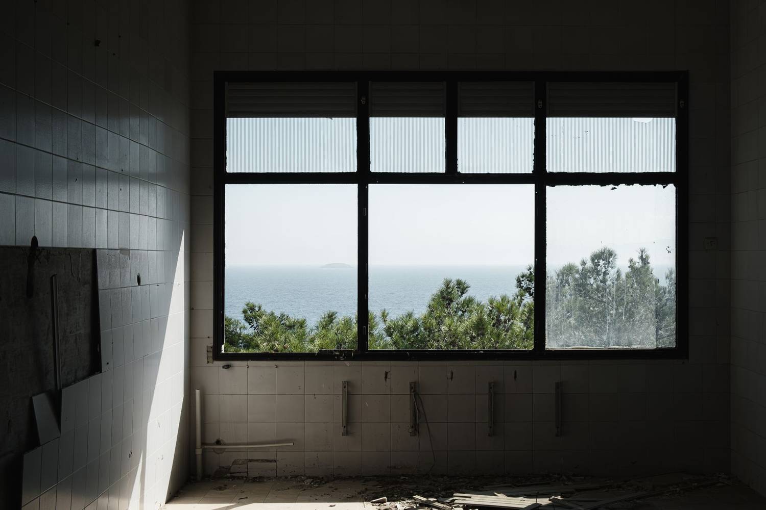 An empty room with large windows providing a serene ocean view, capturing tranquility.