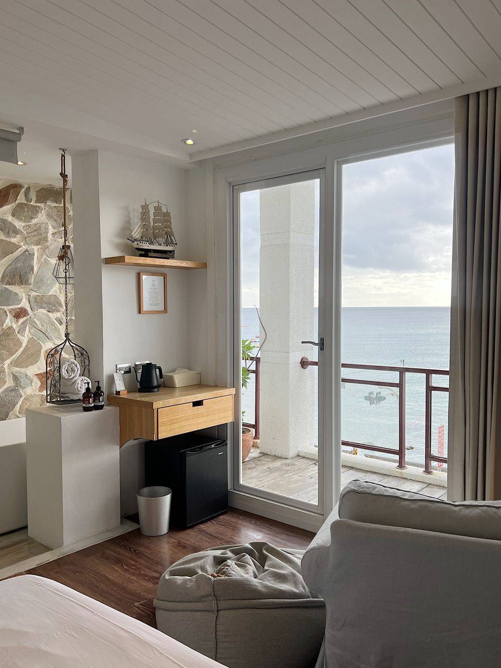 Charming room with a sea view through large windows and a cozy interior.