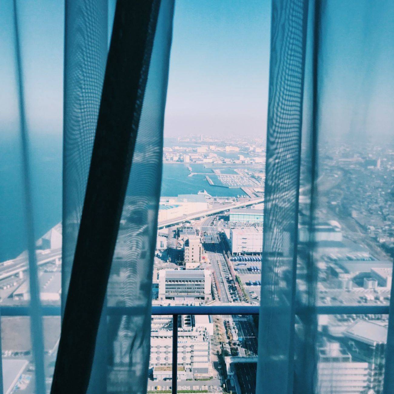 Breathtaking cityscape of Osaka with a stunning ocean view through a hotel window.