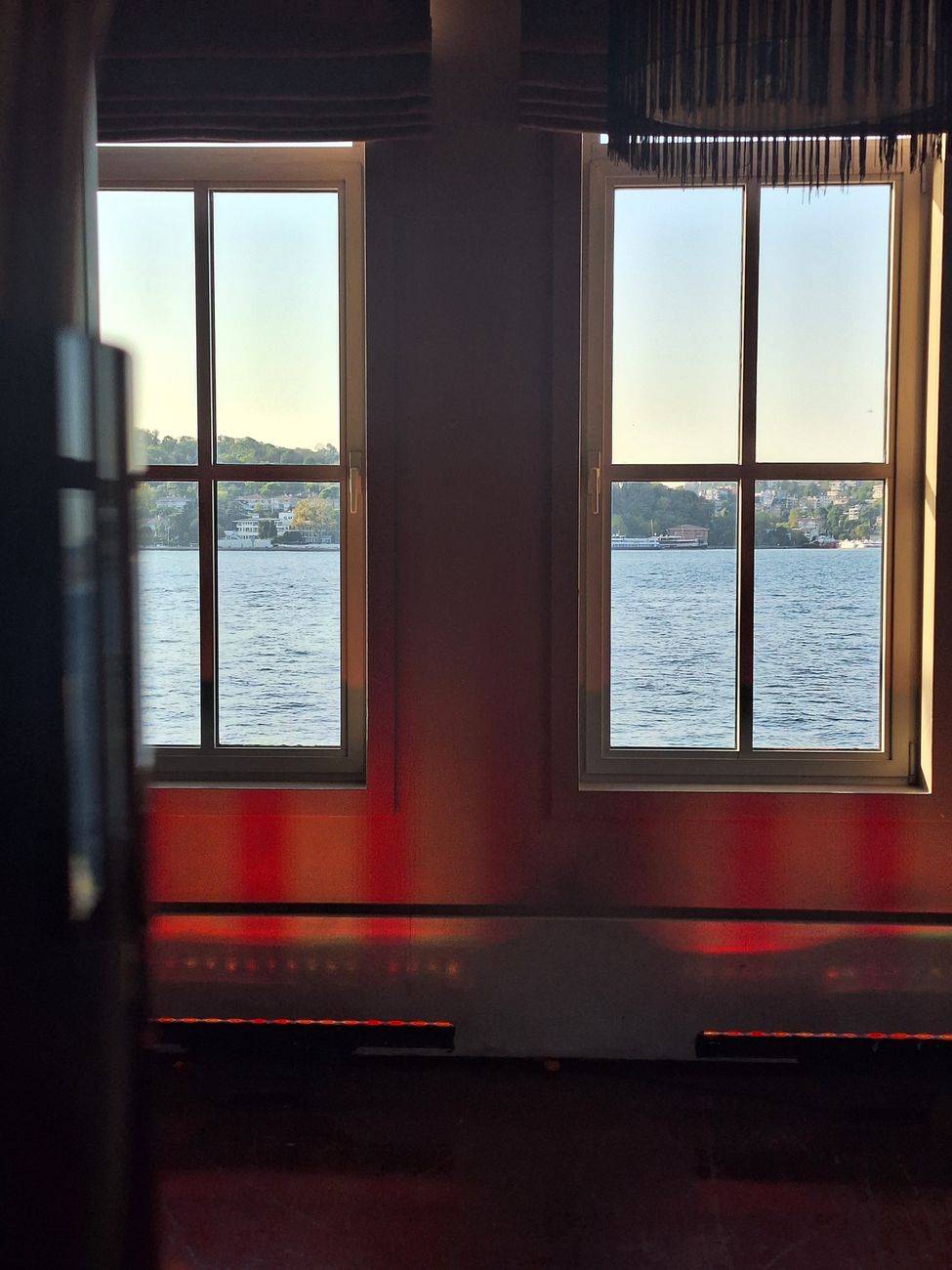 Interior view with two windows showcasing a scenic Istanbul coastal landscape.